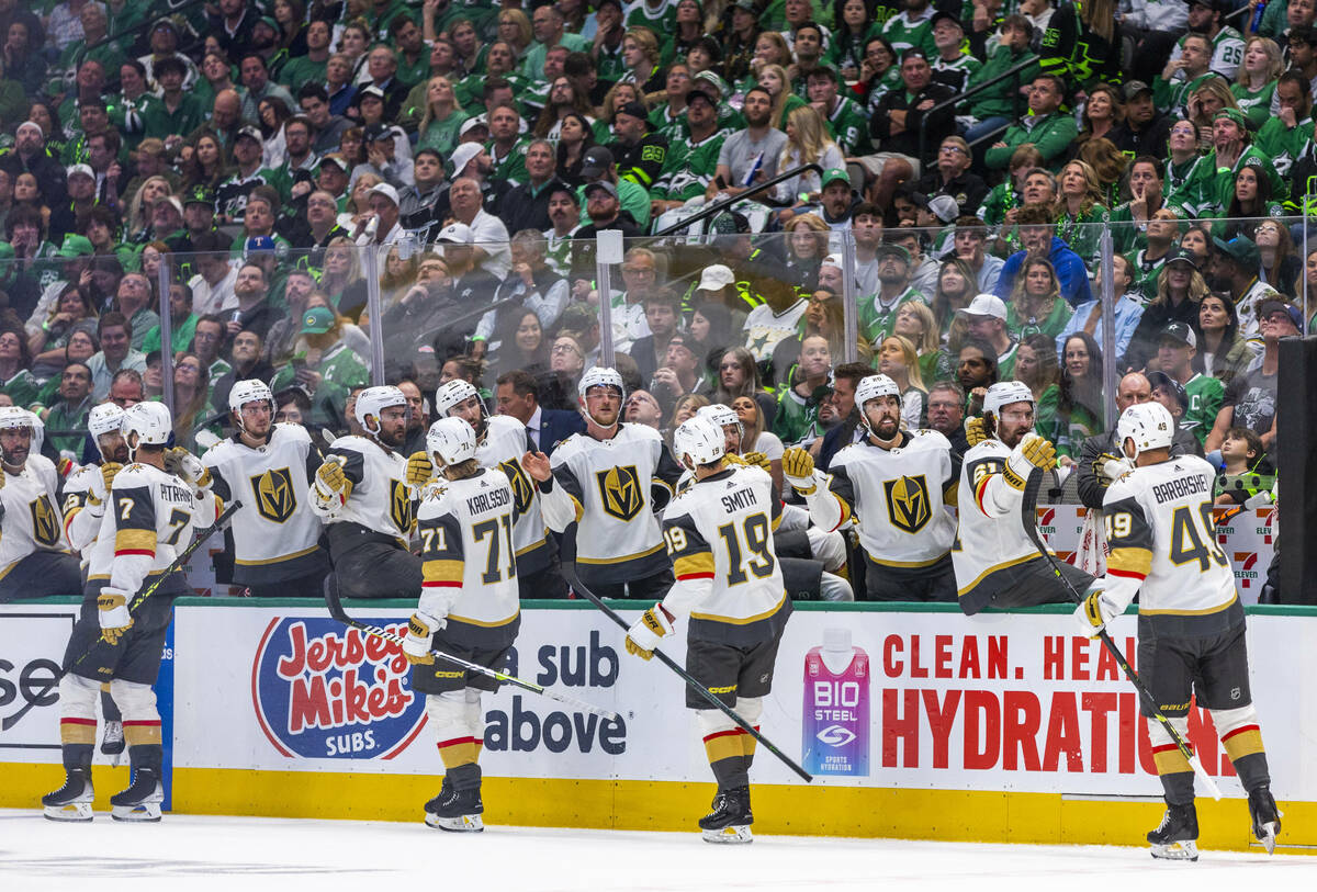 Golden Knights players celebrate their second goal past Dallas Stars goaltender Jake Oettinger ...