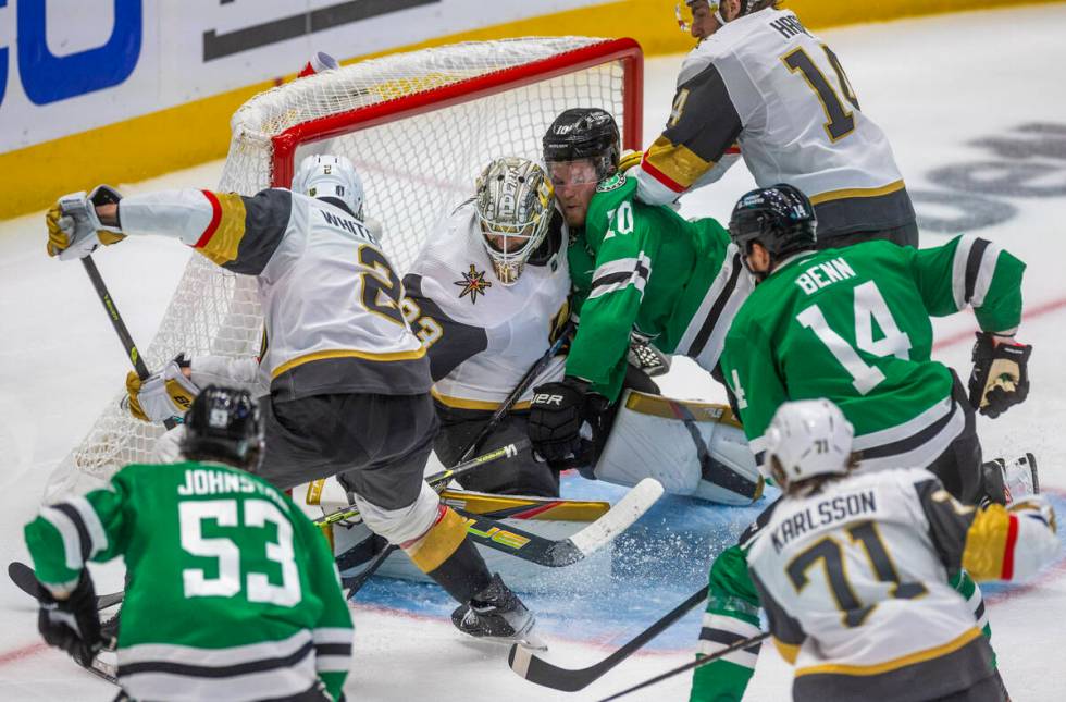 Golden Knights goaltender Adin Hill (33) traps a shot by Dallas Stars center Ty Dellandrea (10) ...