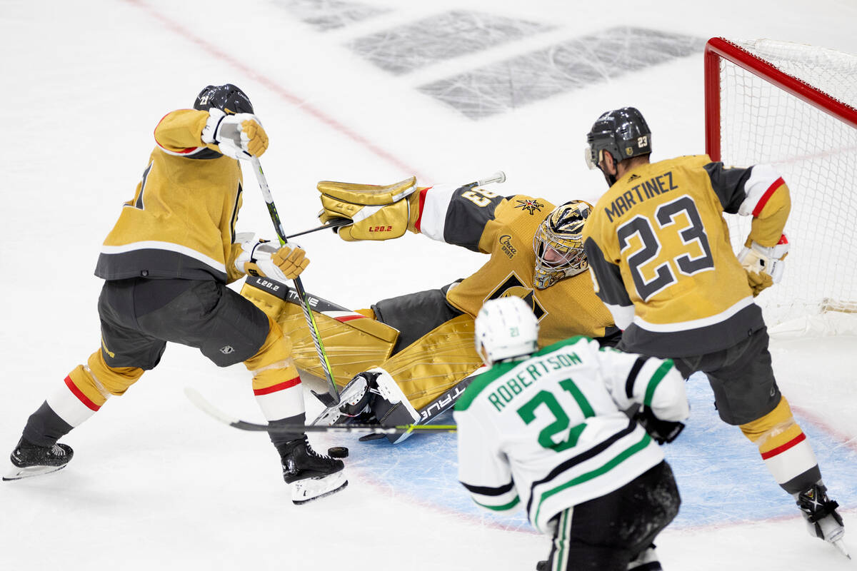 Golden Knights goaltender Adin Hill (33) saves a shot by Dallas Stars goaltender Jake Oettinger ...