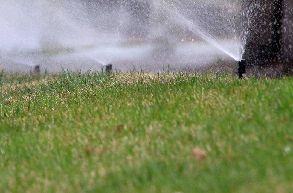 Lawn sprinklers are on to water grass at Green Valley Parkway on Tuesday, March 5, 2019, in Hen ...