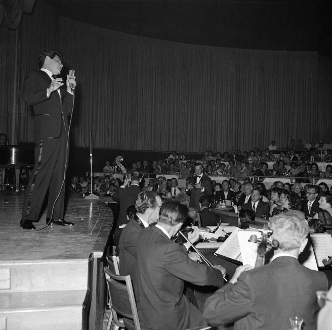 Elizabeth Taylor, in the audience at far right, listens as Eddie Fisher sings love songs to her ...