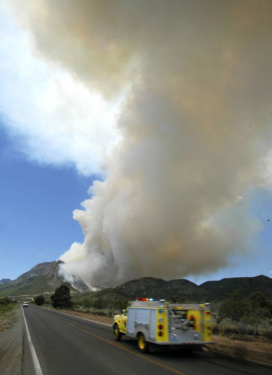 A fire truck moves up into a forward position to fight the Robber's fire on Mount Charleston, M ...