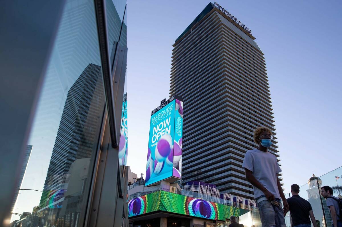 Visitors to the Las Vegas Strip cross a pedestrian bridge outside Cosmopolitan of Las Vegas in ...