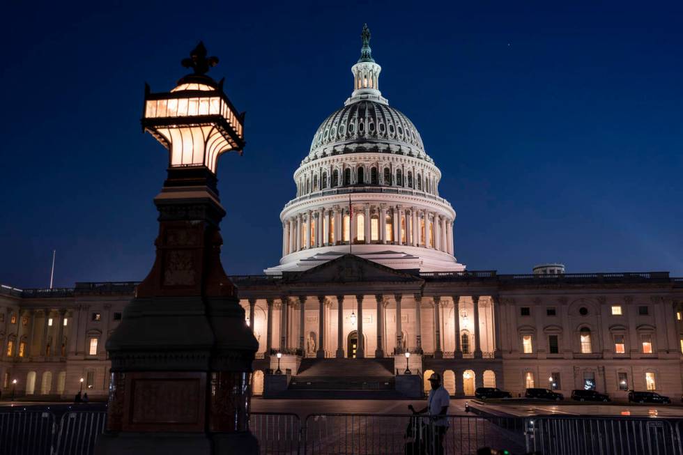 Days away from a default crisis, the Capitol is illuminated as the Senate works into the night ...