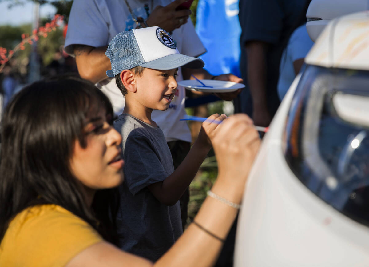 Yelena Morales, left, and Klaus Gonzalez paint a picture on a new Honda SUV provided by Findlay ...