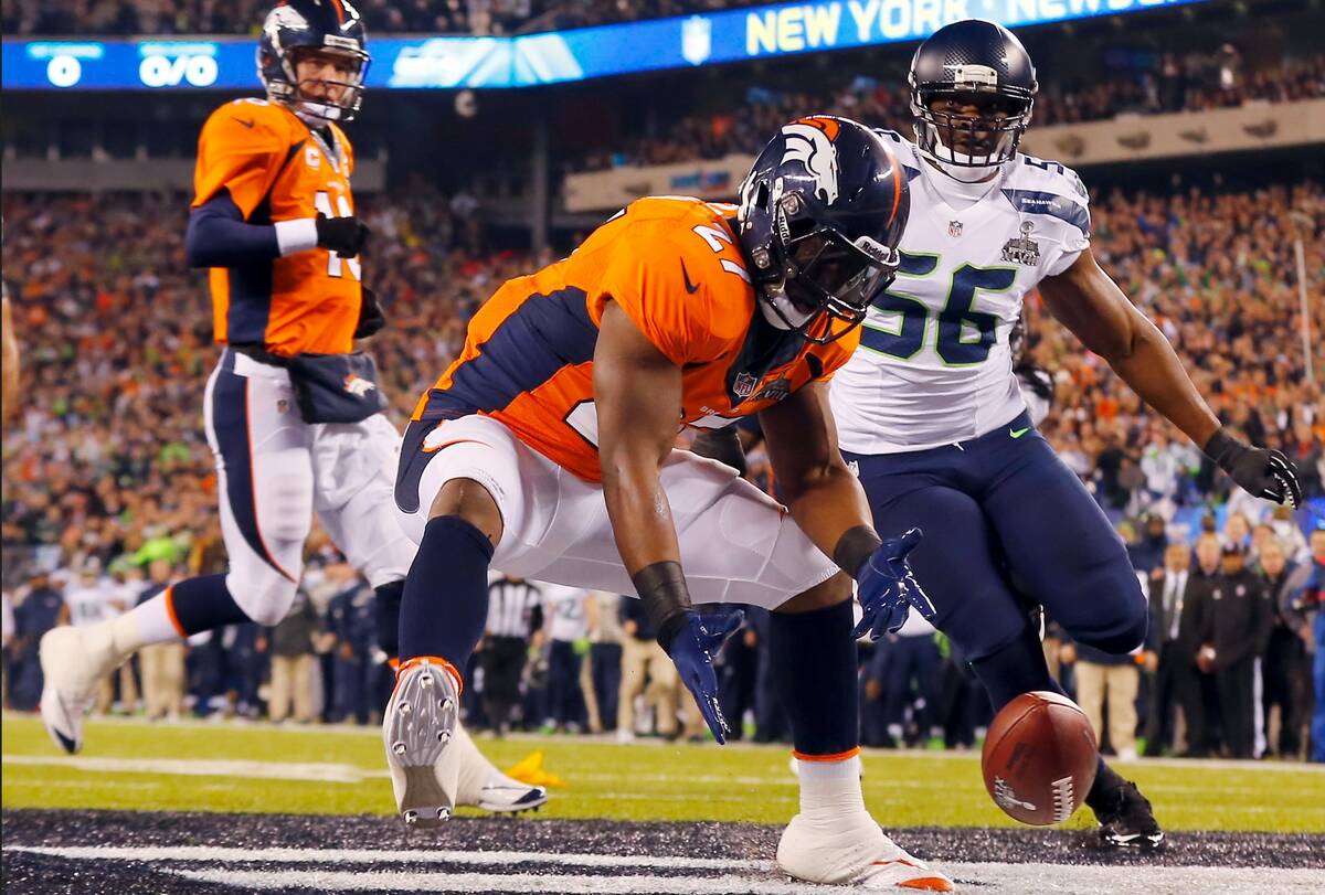 Denver Broncos' Knowshon Moreno reaches for a loose ball after the snap passed teammate Peyton ...