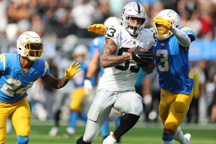 Raiders tight end Darren Waller (83) runs the ball after a catch under pressure from Los Angele ...