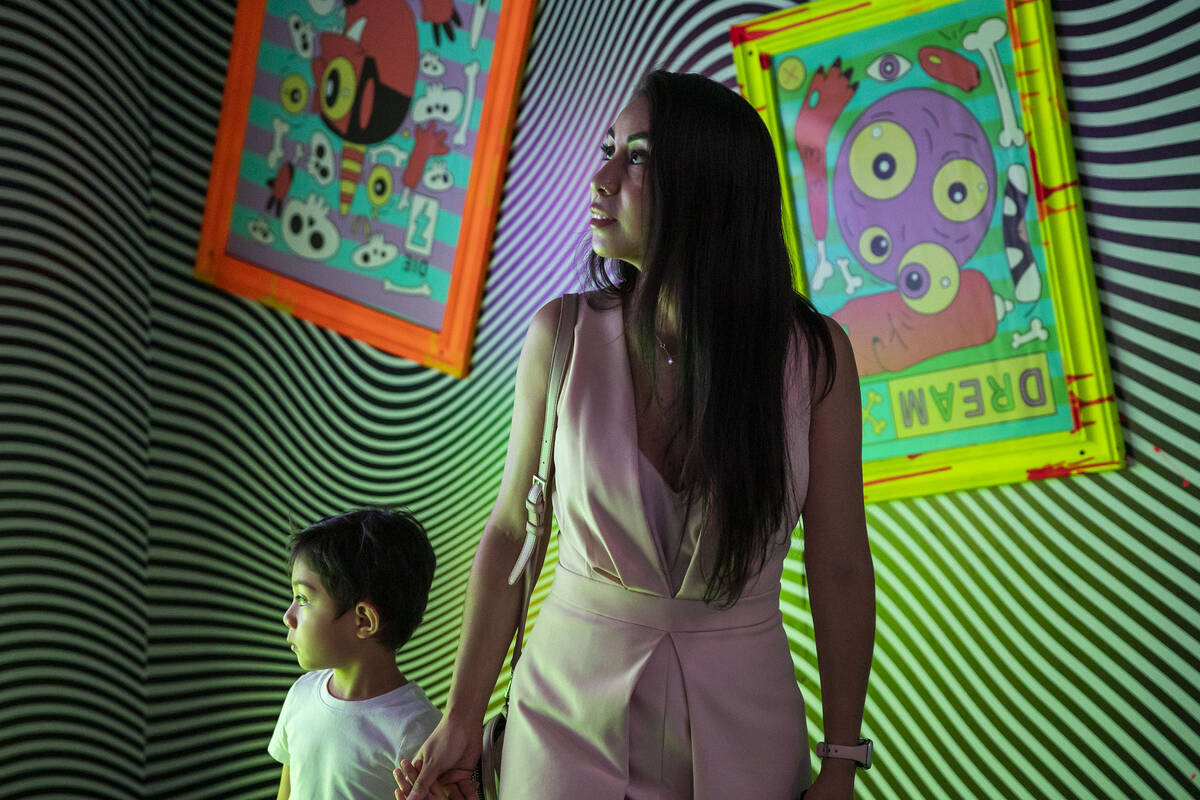 Kim Pineda and Jace Pineda become entranced in a room full of optical illusions during a tour t ...