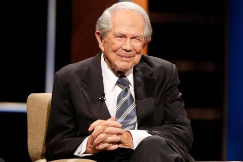 FILE - Rev. Pat Robertson poses a question to a Republican presidential candidate during a foru ...