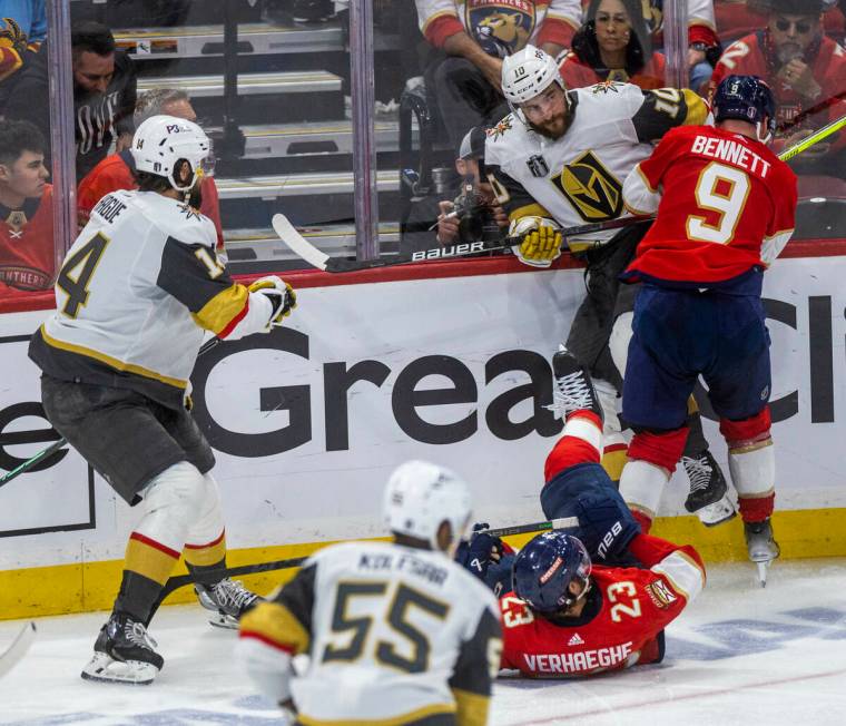 Golden Knights center Nicolas Roy (10) is checked into the boards by Florida Panthers center Sa ...