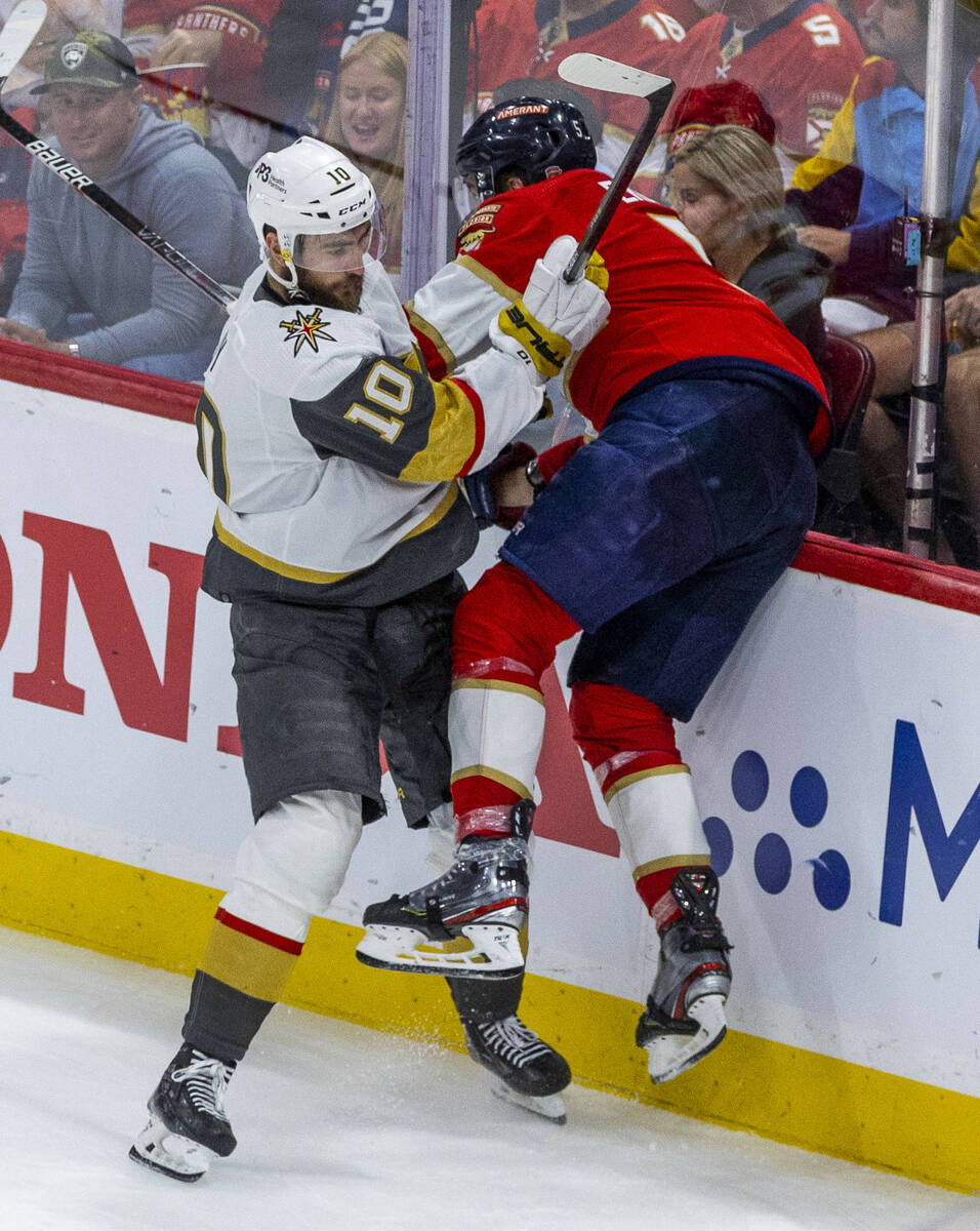 Golden Knights center Nicolas Roy (10) checks Florida Panthers defenseman Aaron Ekblad (5) into ...