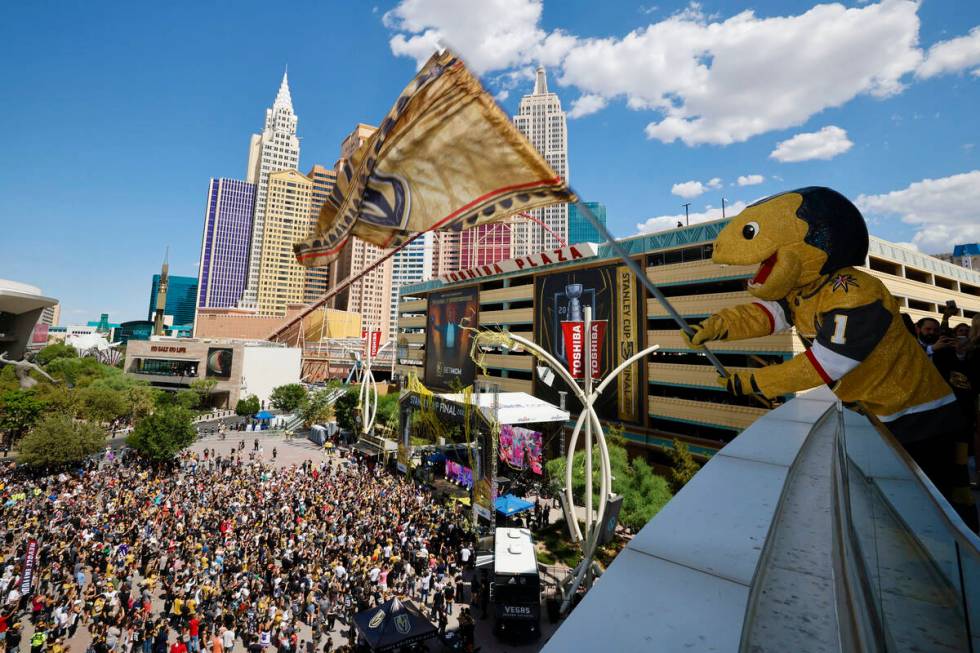 Vegas Golden Knights mascot Chance the Golden Gila Monster flies a flag as DJ Steve Aoki perfor ...