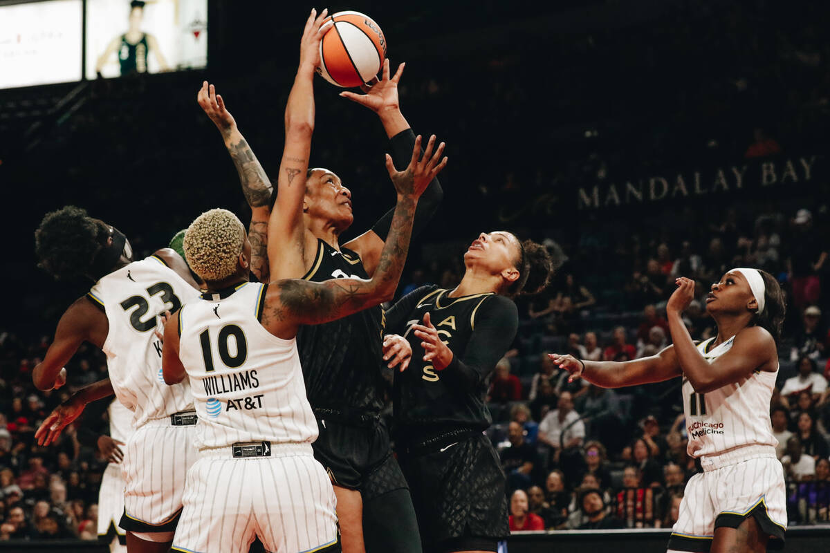 Aces center A’ja Wilson (22) shoots the ball as Chicago Sky players attempt to guard her ...