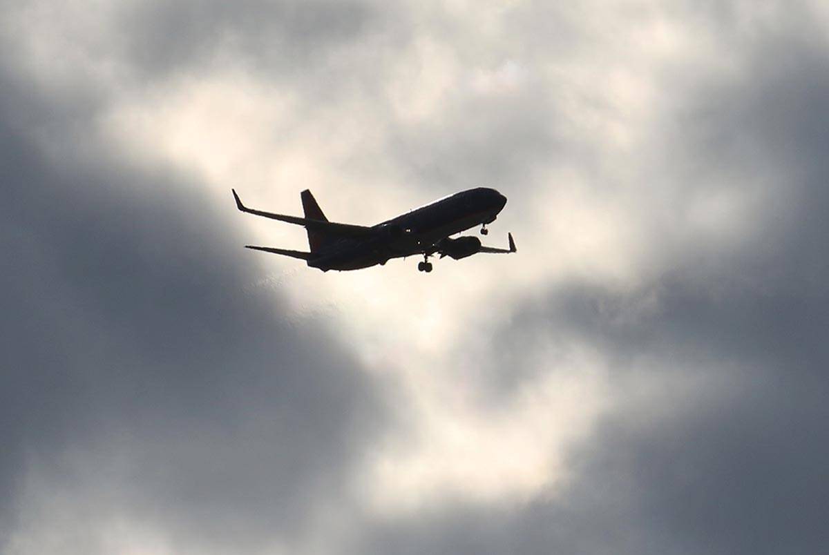 A Sun Country Airlines plane flies under cloudy skies as it approaches Harry Reid International ...