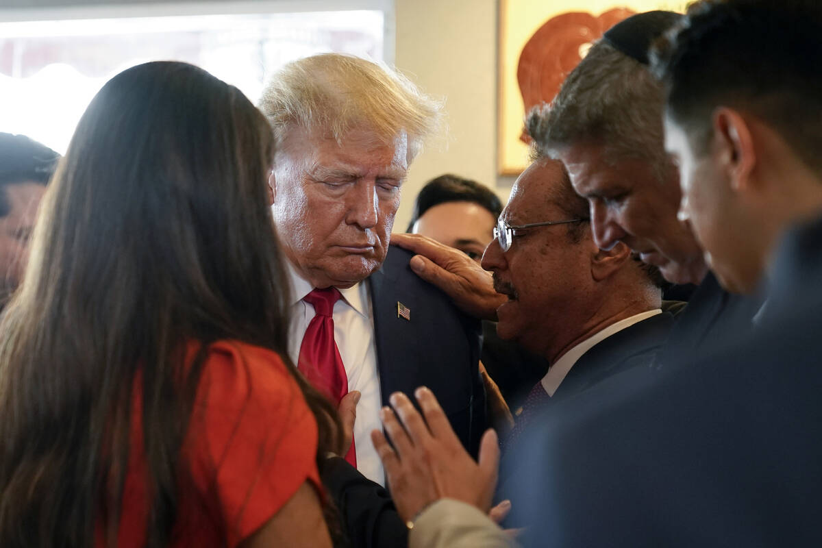 Former President Donald Trump prays with pastor Mario Bramnick, third from right, and others at ...
