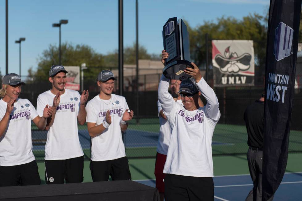 UNLV coach Owen Hambrook raises the Mountain West championship trophy at UNLV's Fertitta Tennis ...