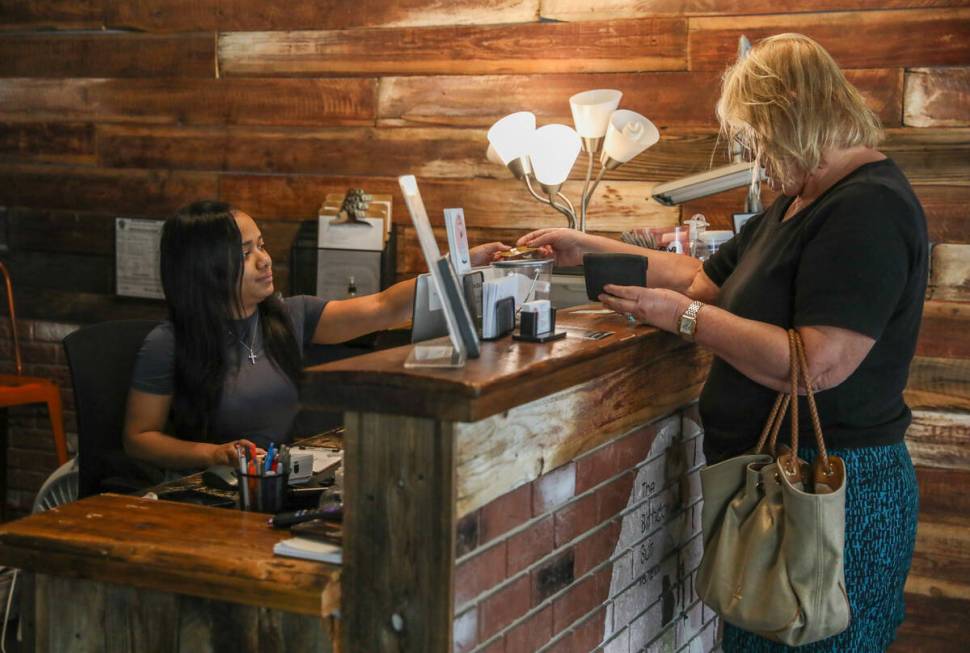 Ava Muhammed, front desk associate, checks out a customer at The Birthday Suit, a waxing spa, o ...