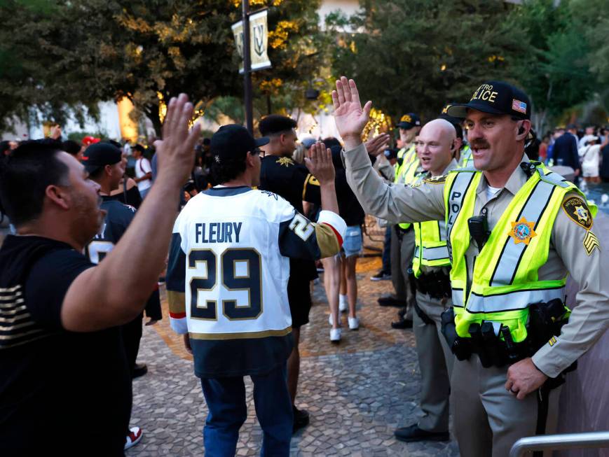 Golden Knights fans and Las Vegas police officers exchange high-fives their team''s Stanley Cup ...