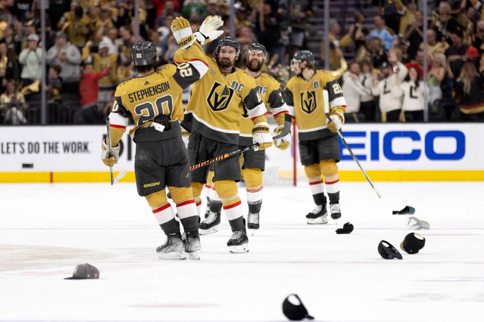 Hats litter the ice while Golden Knights right wing Mark Stone (61) slaps hands with center Cha ...