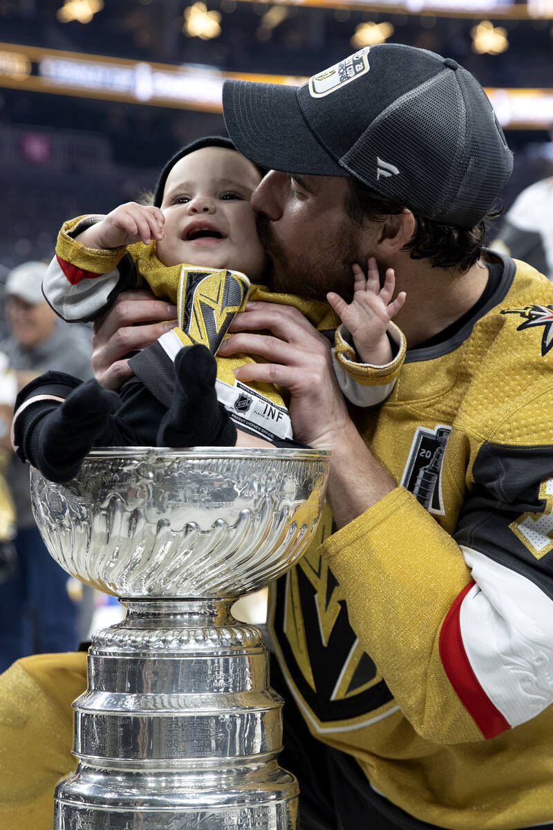 Golden Knights right wing Reilly Smith kisses his daughter Isla, sitting in the Stanley Cup, af ...