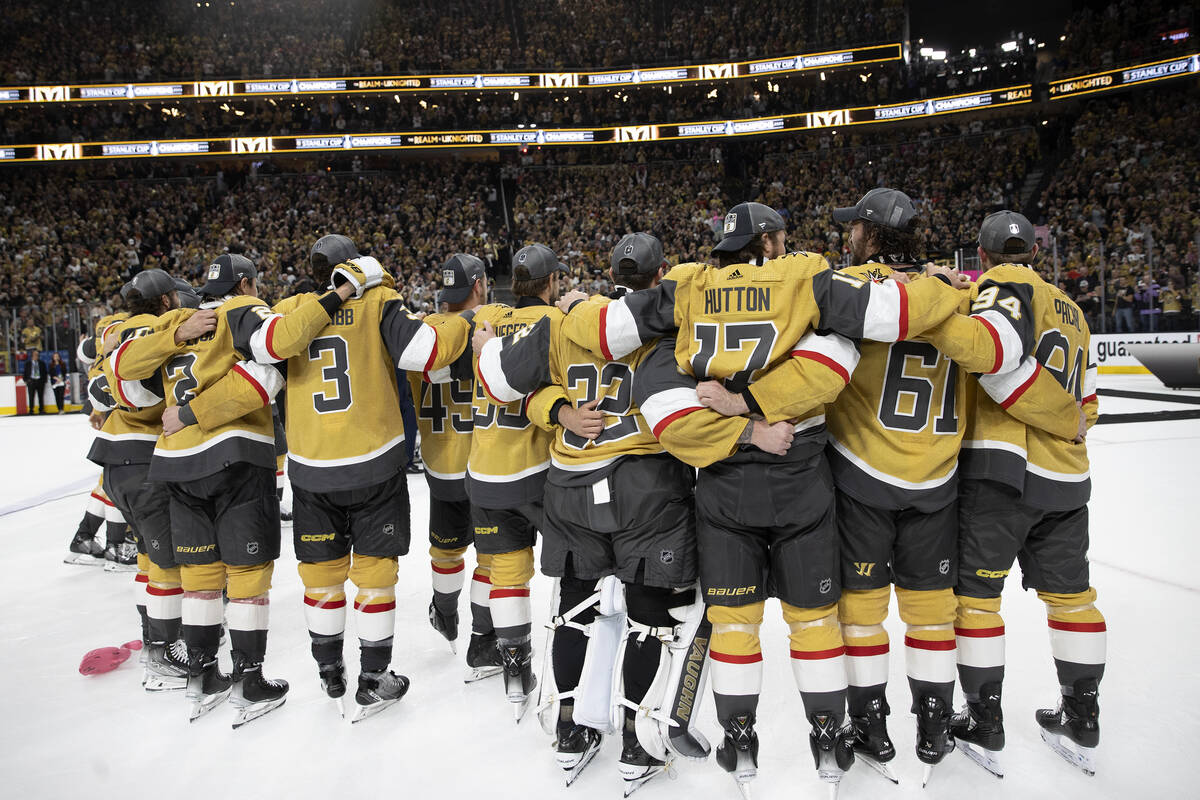 The Golden Knights embrace as they are about to be presented the Stanley Cup after their NHL ho ...
