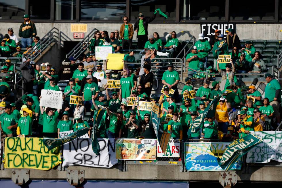 Fans hold signs at Oakland Coliseum to protest the Oakland Athletics' planned move to Las Vegas ...