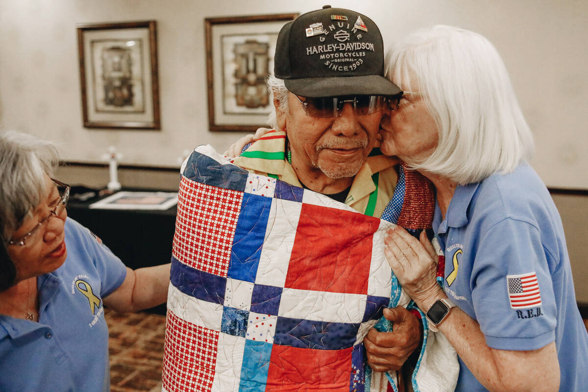 Dalton Tom receives a kiss on the cheek from Quilts of Valor Foundation volunteer Wanda Smith a ...