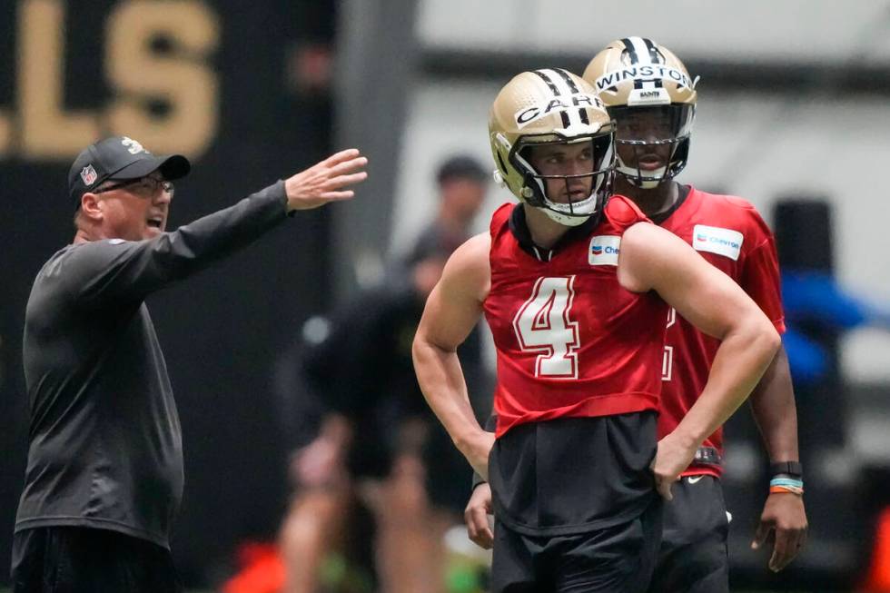 New Orleans Saints offensive coordinator Pete Carmichael instructs quarterbacks Derek Carr (4) ...