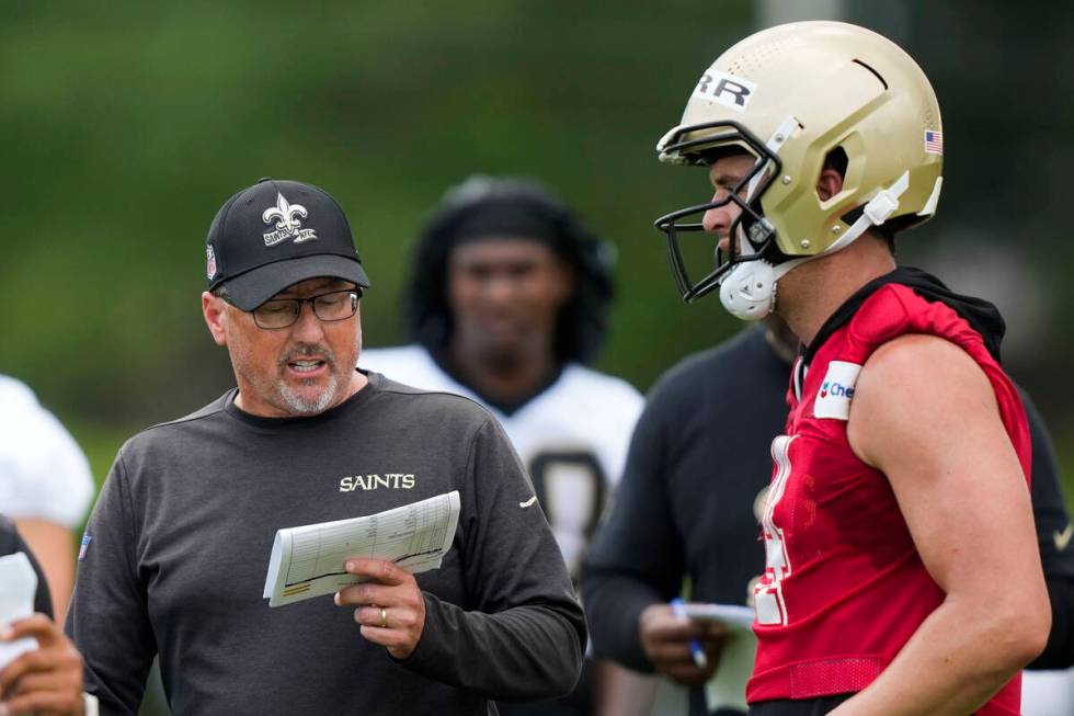 New Orleans Saints offensive coordinator Pete Carmichael talks with quarterback Derek Carr duri ...