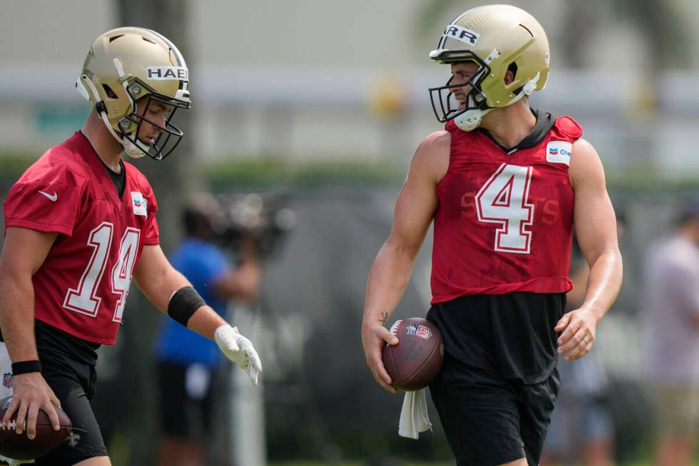 New Orleans Saints quarterbacks Derek Carr (4) and Josh Haener (14) walk through drills during ...