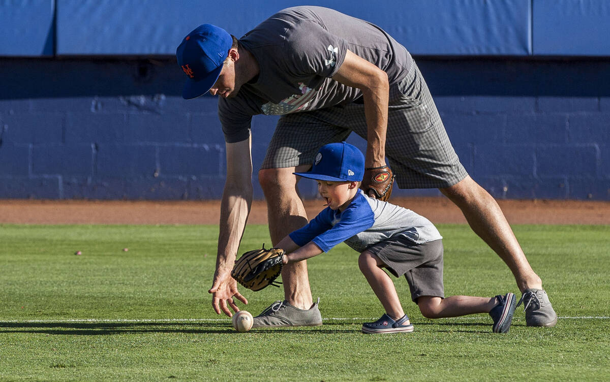 Dillon Truman, 4, races for the ball with his father Jared during father and child catch, an an ...