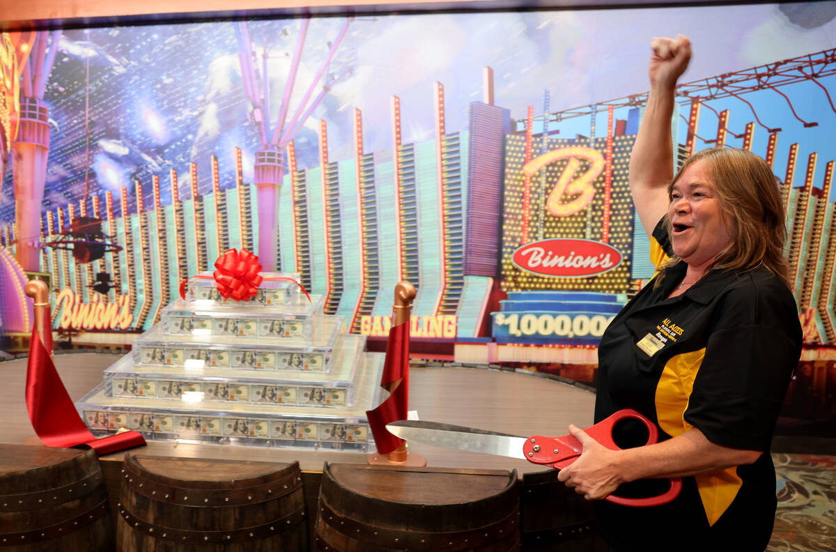 Slot Club Manager Julie Childers cuts the ribbon to open the new Million Dollar Display at Bini ...