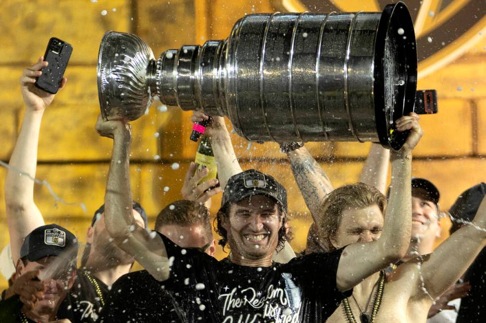 Golden Knights right wing Mark Stone (61) is showered with champagne while holding up the Stanl ...