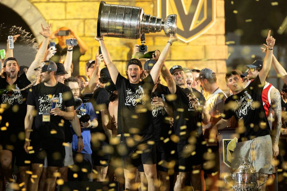 Golden Knights center Brett Howden, center, cheers with the Stanley Cup as confetti rains down ...