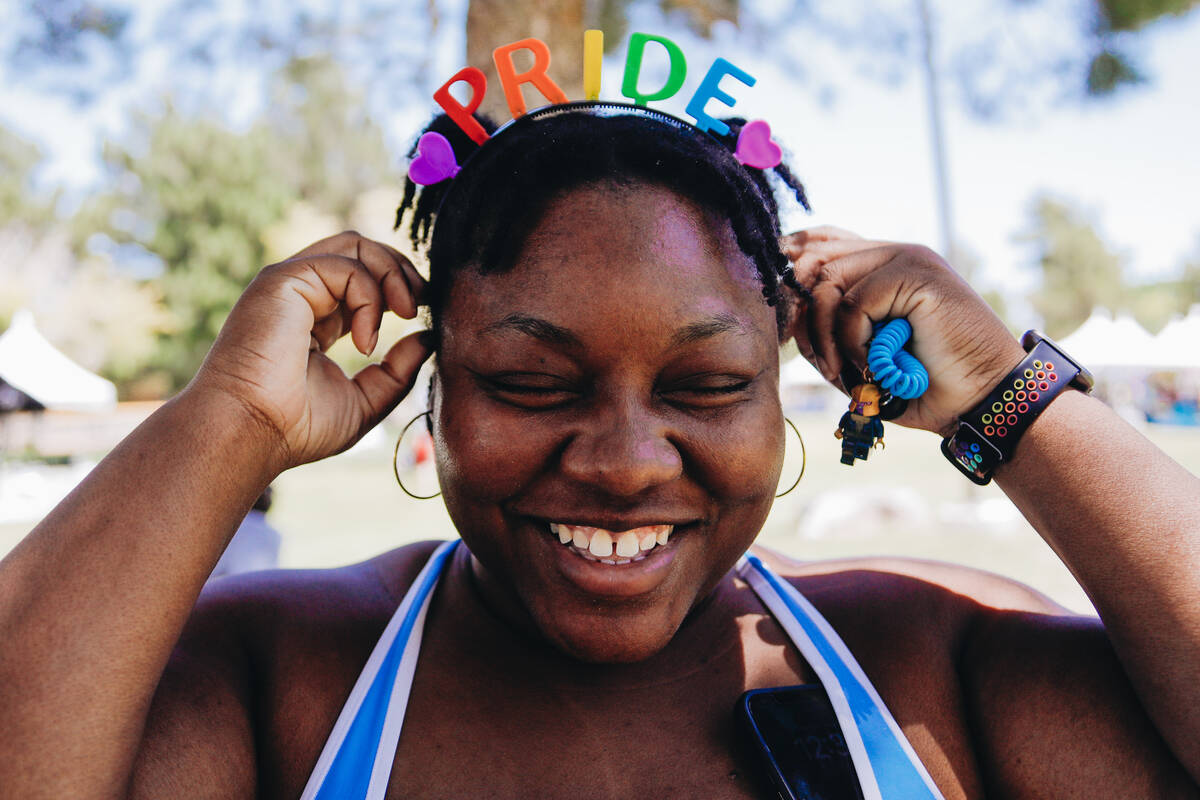 Acacia Dorsey puts an LGBTQ+ pride headband on their head during Henderson Pride Fest on Saturd ...