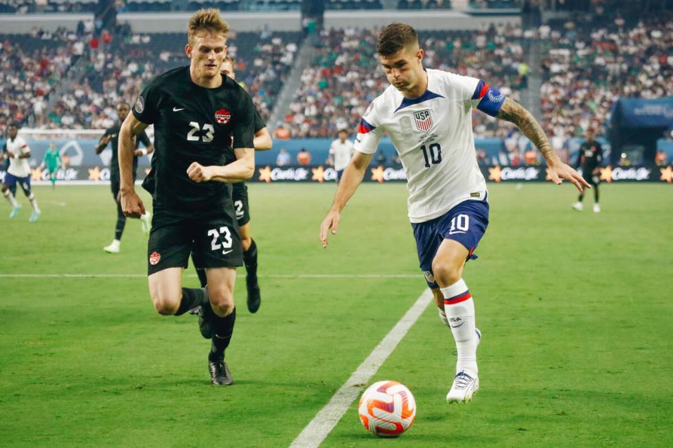 Team USA’s Christian Pulse (10) kicks the ball as Team Canada’s Scott Kennedy (23 ...