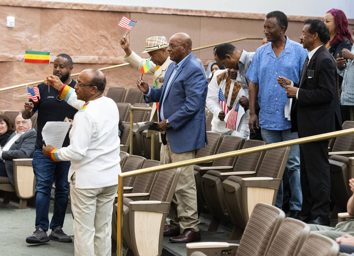 People wave Ethiopian and American flags as they cheer in the Clark County Commission chambers ...