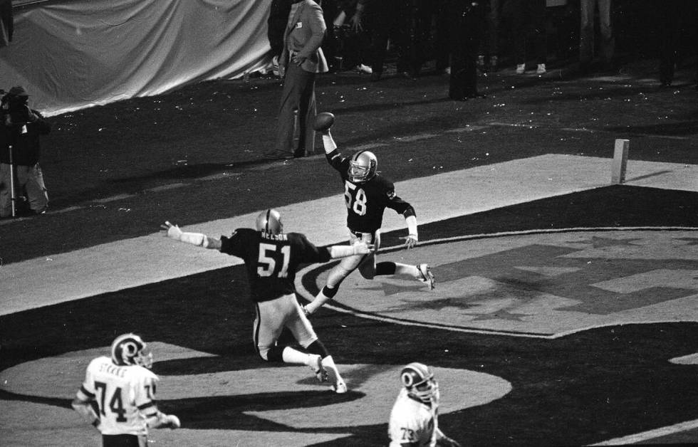 Los Angeles Raiders Jack Squirek (58) holds the ball aloft in the end zone after intercepting a ...