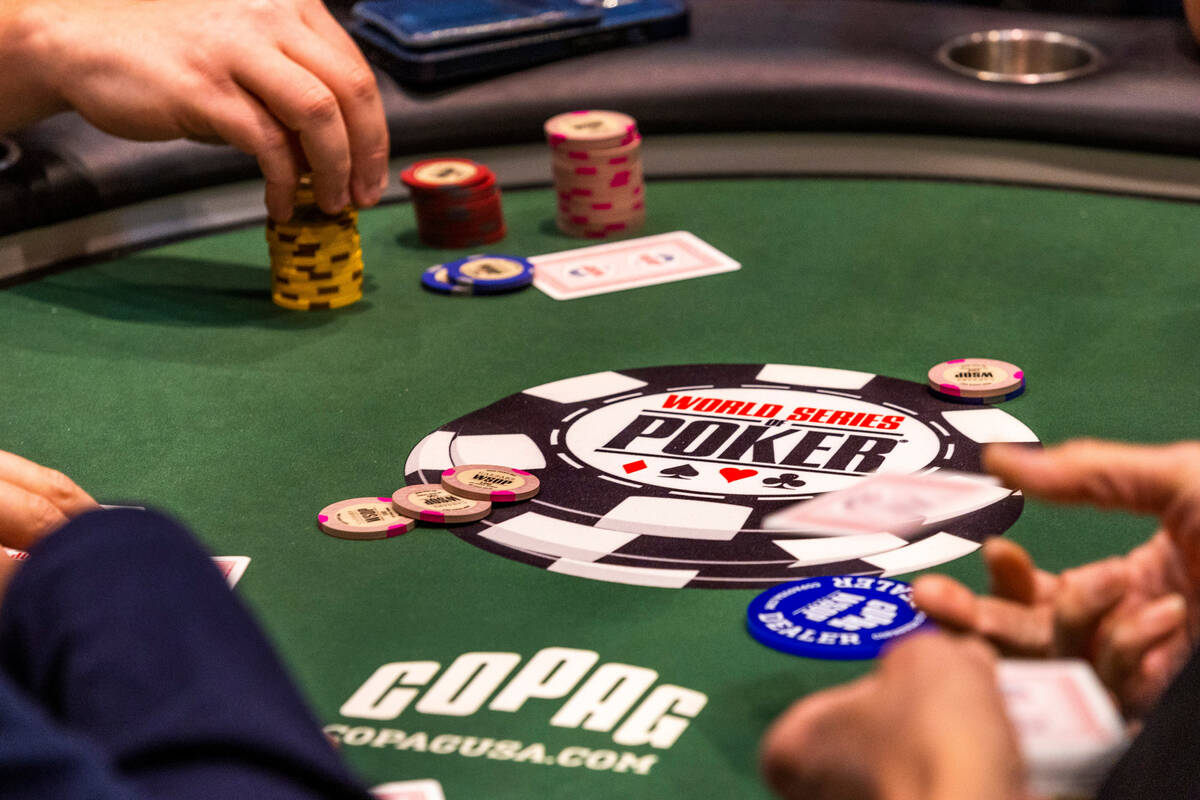 A dealer throws out a second card to poker player Shaun Deeb at his table during the WSOP in th ...