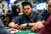 Poker player Shaun Deeb checks out his cards at his table during the WSOP in the Paris on Frida ...