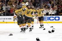 Hats litter the ice while Golden Knights right wing Mark Stone (61) slaps hands with center Cha ...