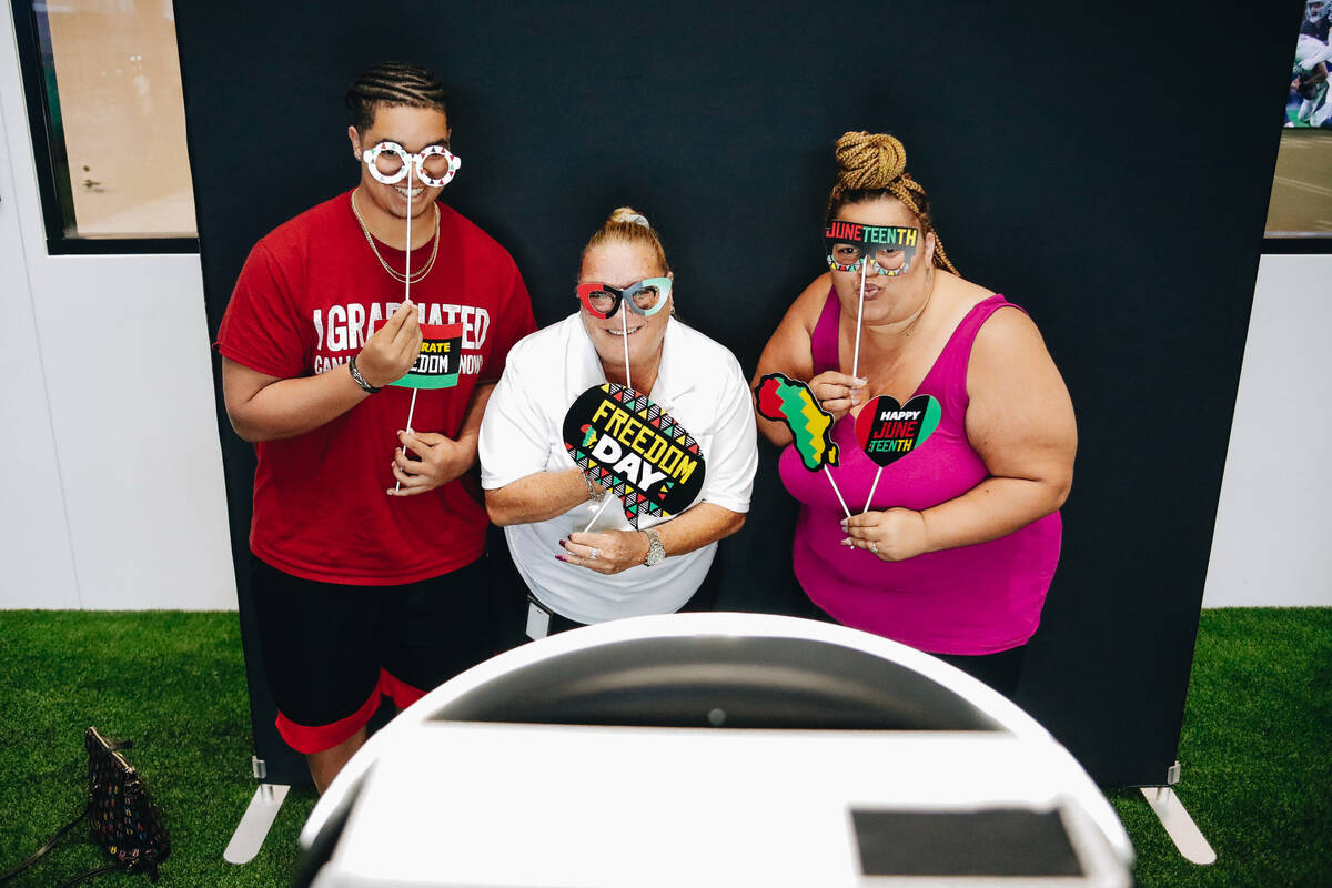 From left: Marcus White, 17, Jackie Kaufman and Jenni White pose for photos at a photo booth on ...