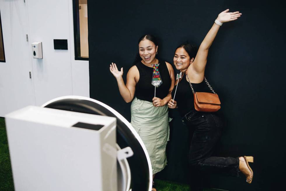 Traci Lampkin, left, and Sopany Polk pose for photos together at a photo booth during a Junetee ...