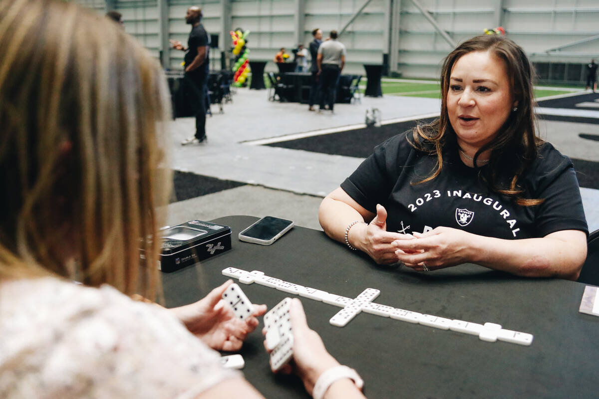 Angelina La Fontaine, facing, plays Lauren Aguliar in a game of dominoes during a Juneteenth ce ...