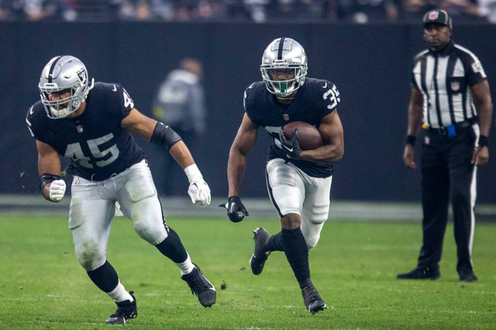 Raiders running back Zamir White (35) follows Raiders fullback Jakob Johnson (45) on a run agai ...