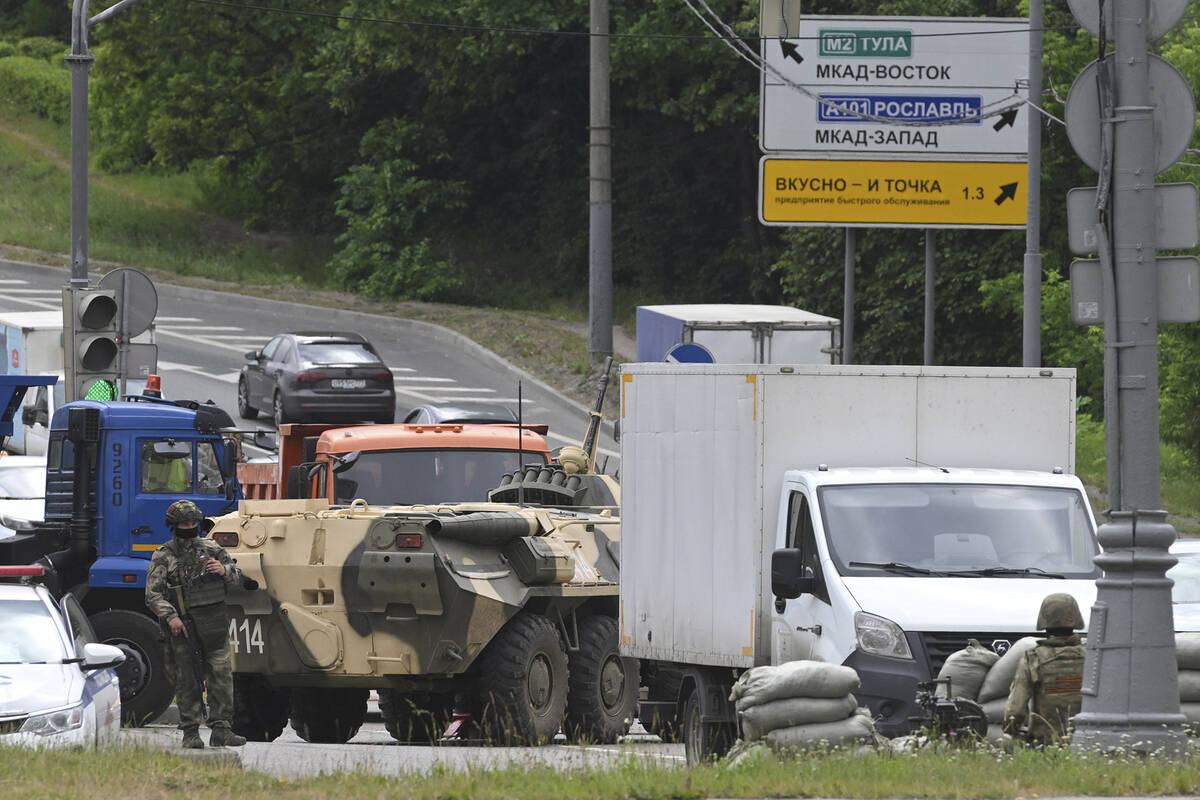 Russian army servicemen with an APC guard the highway at the entrance to Moscow, Russia, Saturd ...