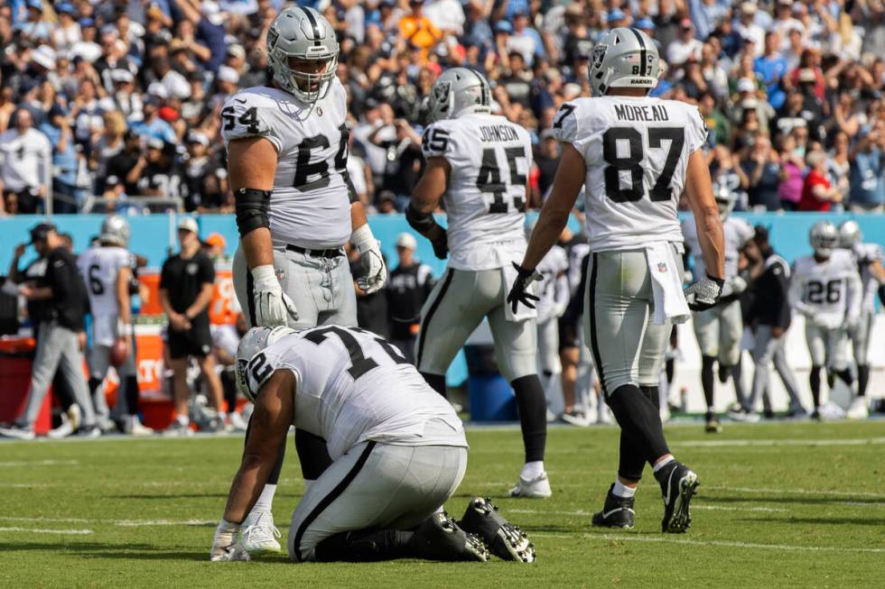 Raiders guard Alex Bars (64) consoles Raiders offensive lineman Jermaine Eluemunor (72) in the ...