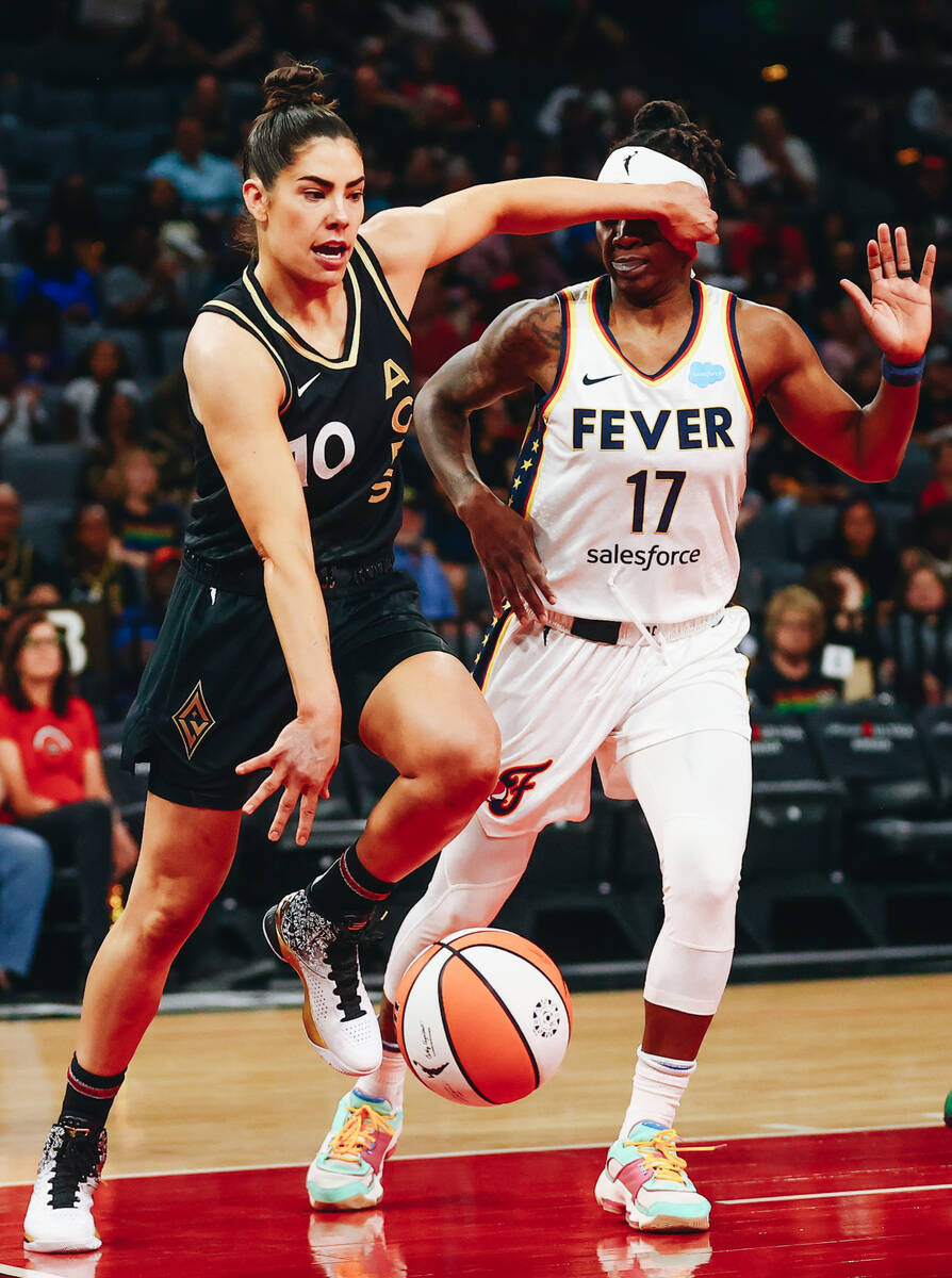 Las Vegas Aces guard Kelsey Plum (10) pushes away Indiana Fever guard Erica Wheeler (17) as she ...