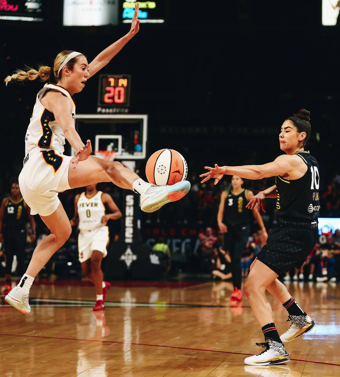 Indian Fever guard Lexie Hull (left) kicks the ball as Las Vegas Aces guard Kelsey Plum pies to ...