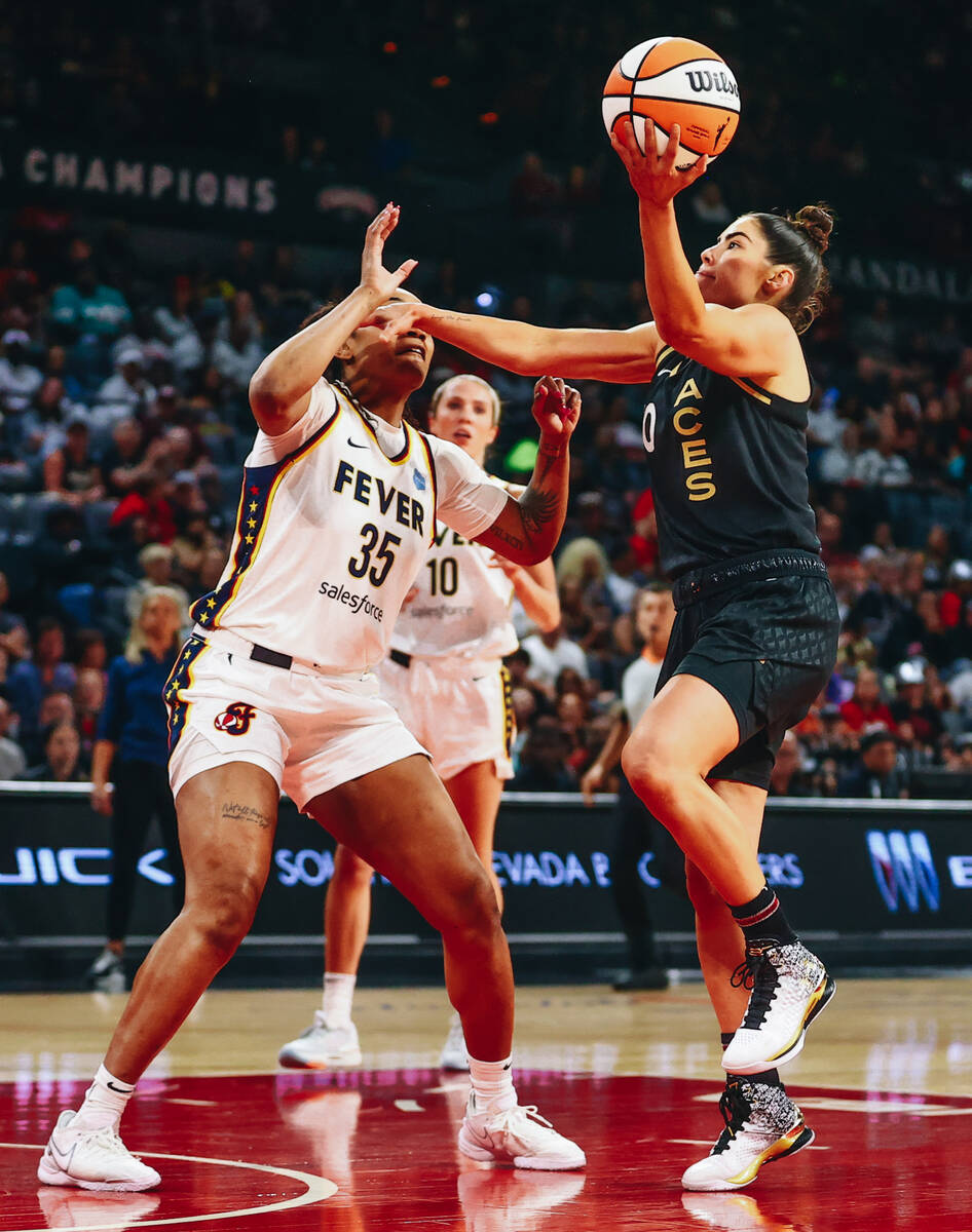 Las Vegas Aces guard Kelsey Plum makes a basket as Indiana Fever guard Victoria Vivians attempt ...